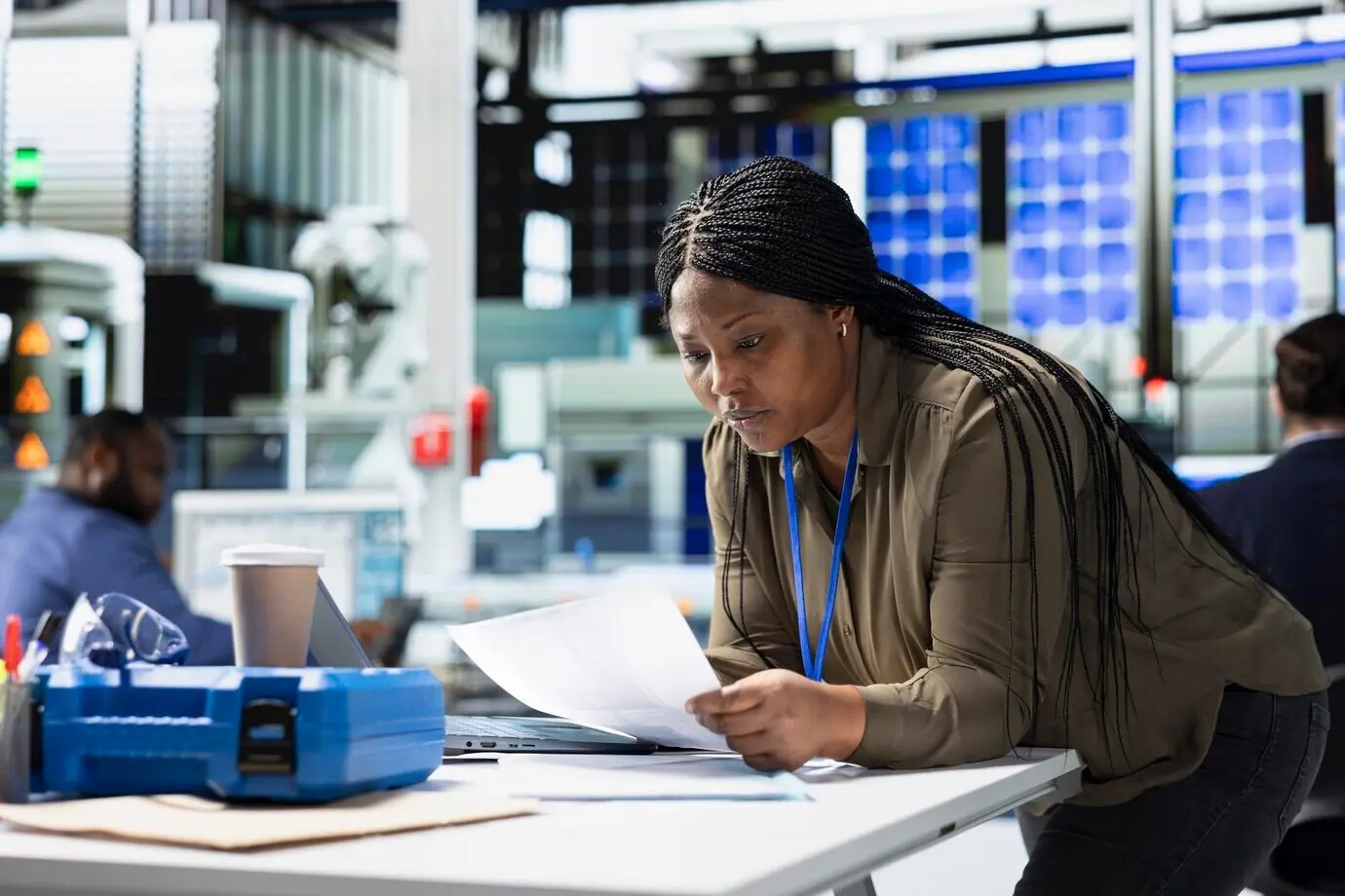 Женщина‑ведущий инженер просматривает данные производственной линии на ноутбуке.