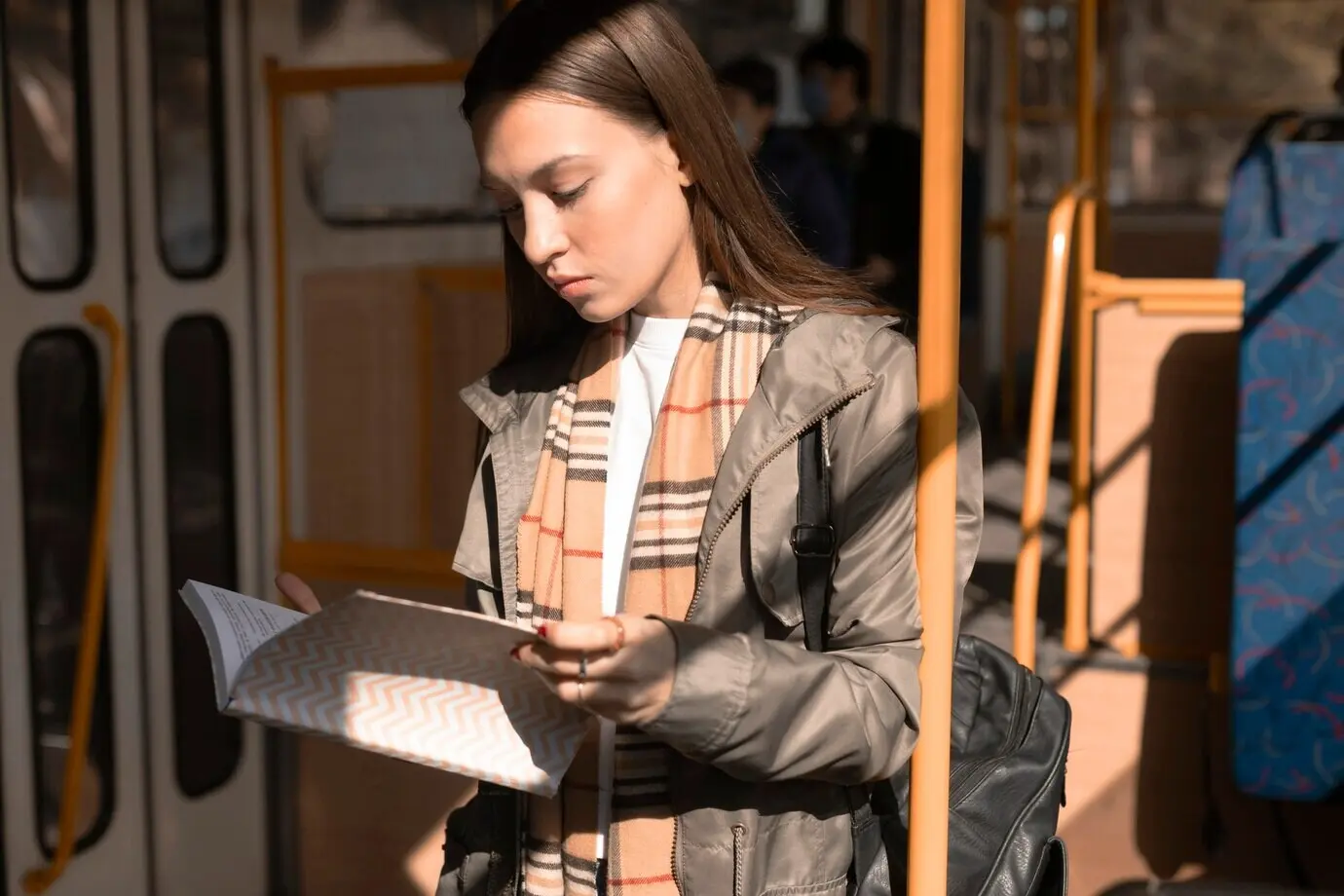 Пассажирка читает во время поездки на трамвае.